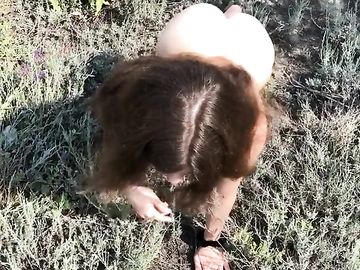 Голая рыжеволосая телка с красивой попкой в траве ищет потерянное колечко